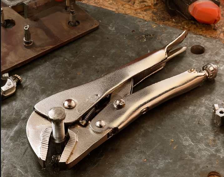 Chrome locking pliers vise-grips on a metal workshop workbench