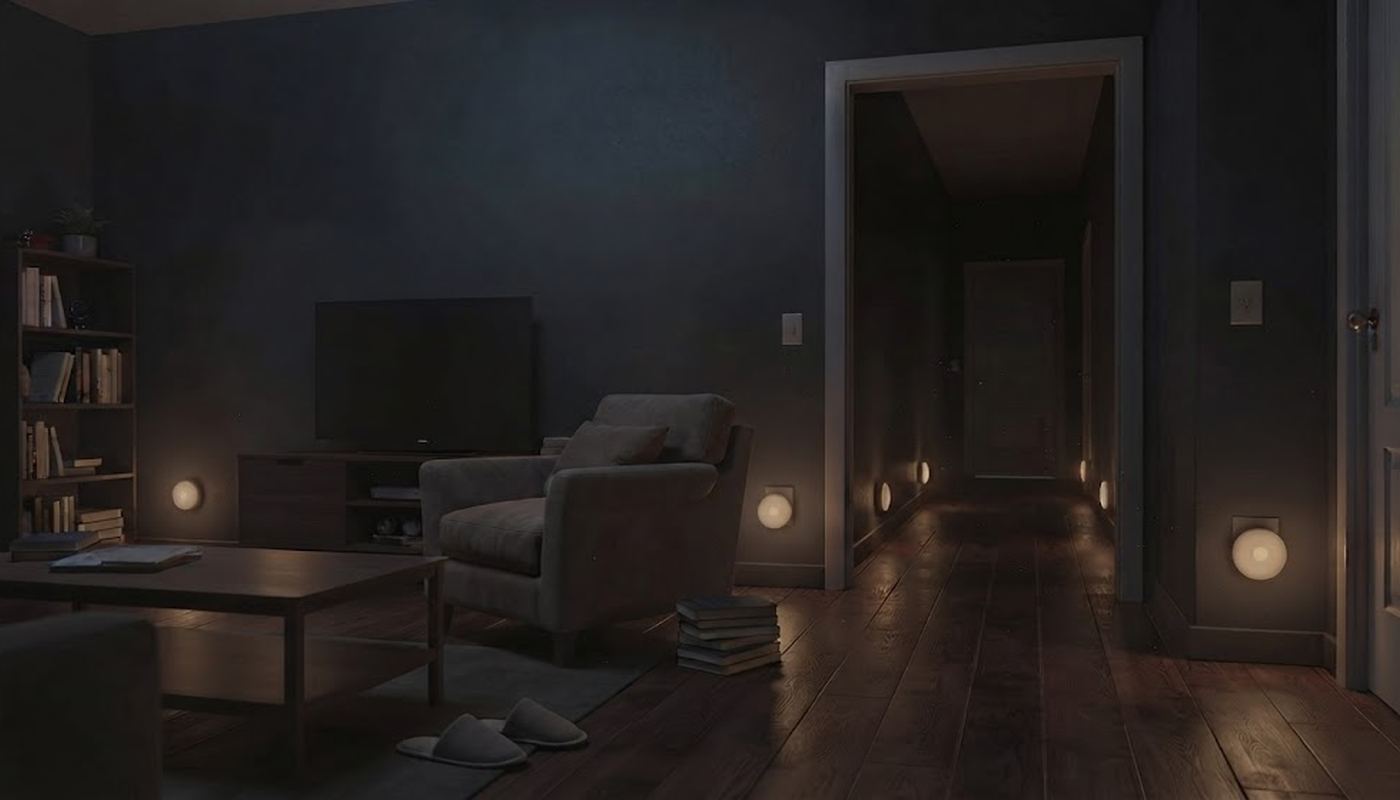LED night lights glowing softly through a dark home — hallway, living room, and front entry all visible without a single switch