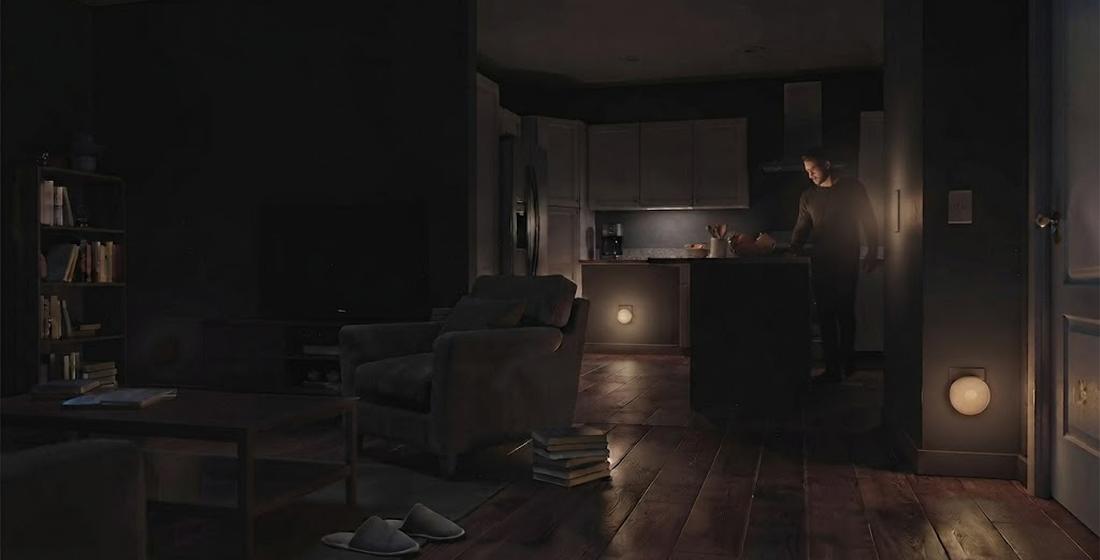 The same room with LED night lights — the person at the kitchen counter is clearly visible, identifiable, and the entire space is readable at a glance
