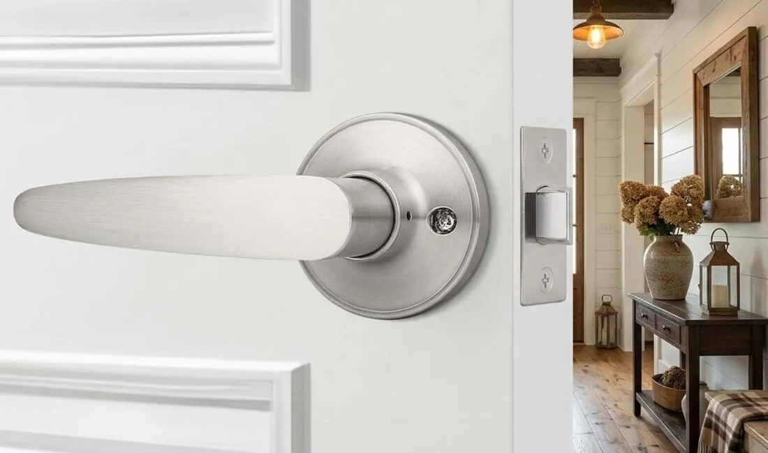 Brushed nickel lever door handle on a white interior door, opening into a bright farmhouse hallway